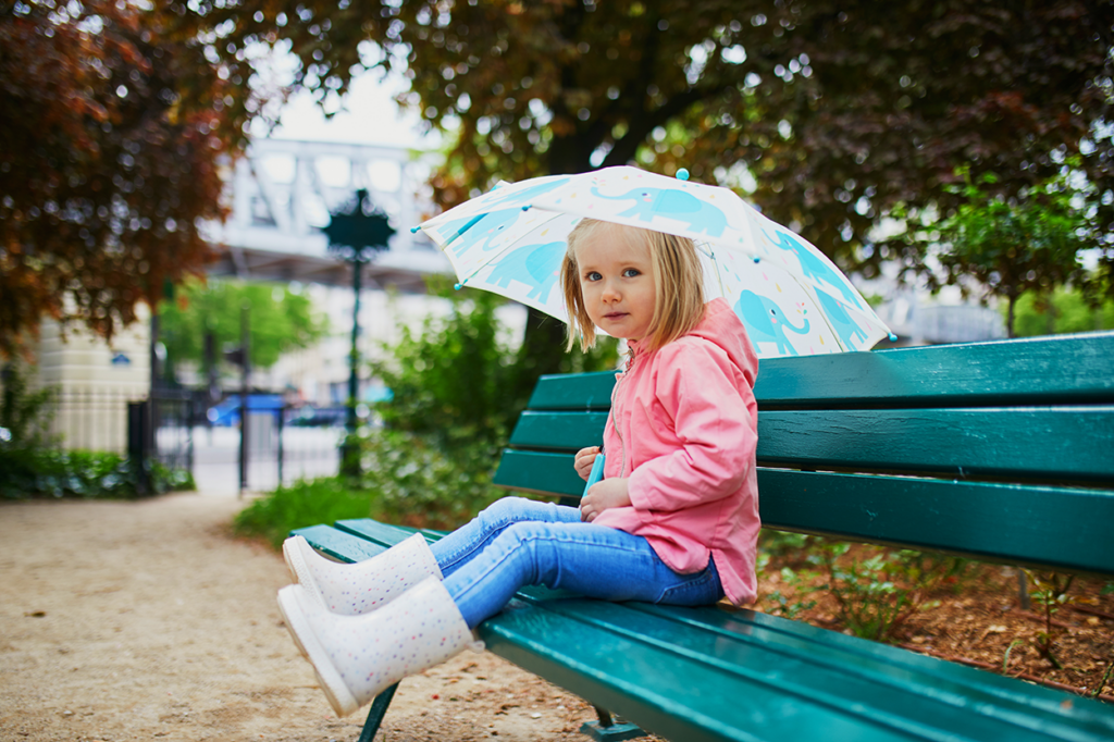 Little girl in the rain in Paris France- credit AdobeStock